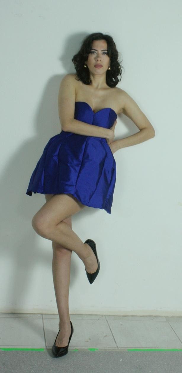 Modelo com vestido azul royal apoiada em uma perna